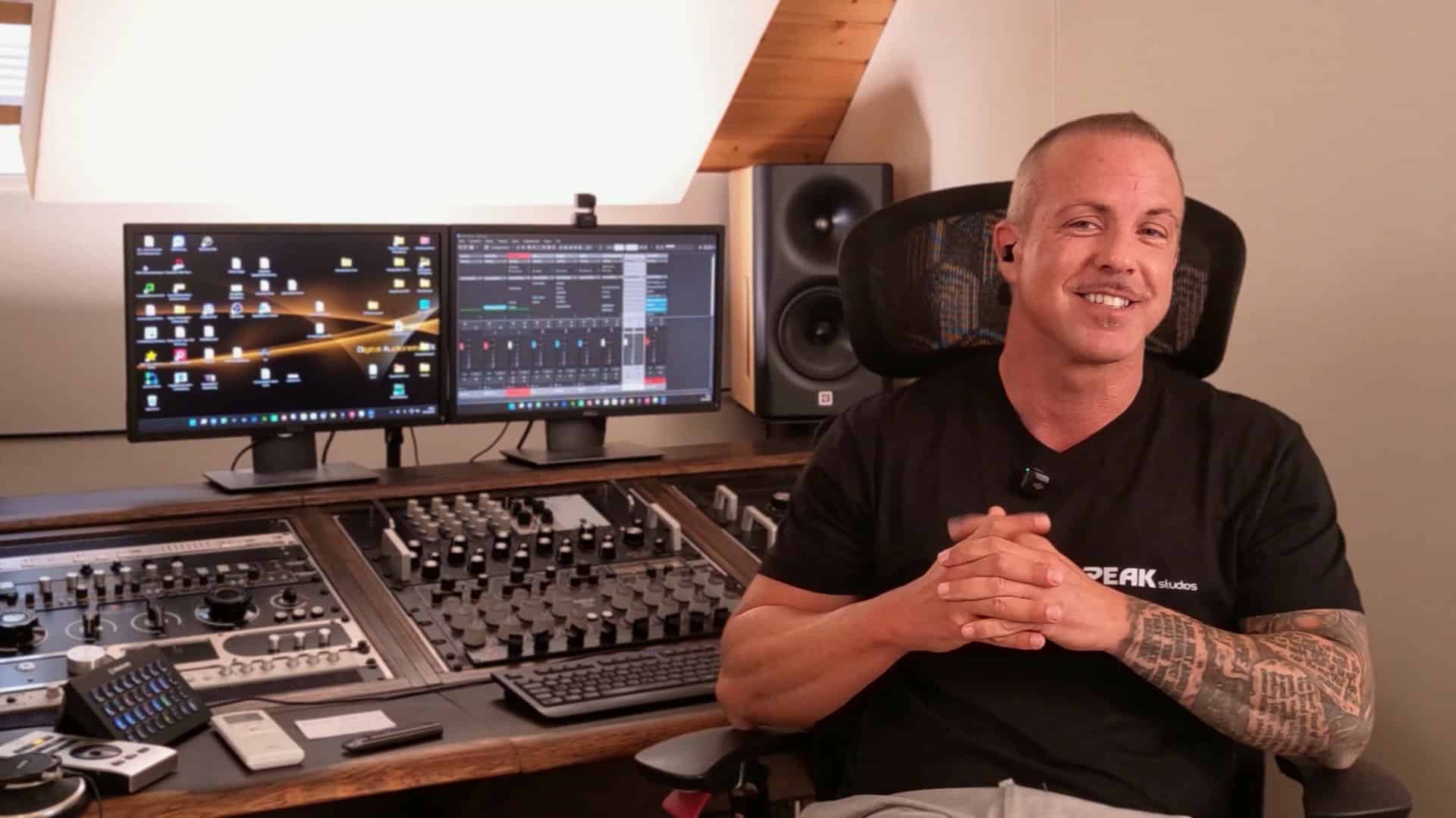 Chris Jones von Peak-Studios lacht, im Hintergrund Studiomonitore und Mischpult